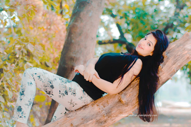 a beautiful girl lying on the tree, using orange and teal effect in outdoor photoshoot, Nikon 50mm 1.8 D