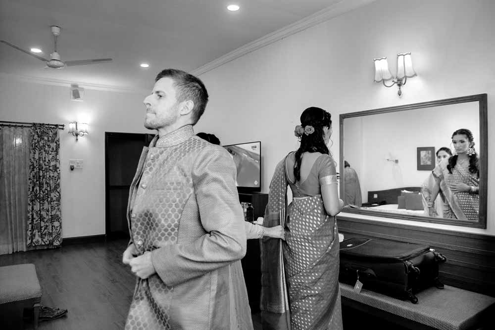 Bride & groom getting ready to wear indian dress before reception ceremony. photojournalism style Black & White image