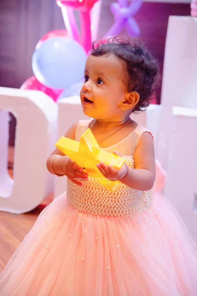 baby girl playing with toy star on her 1st birthday