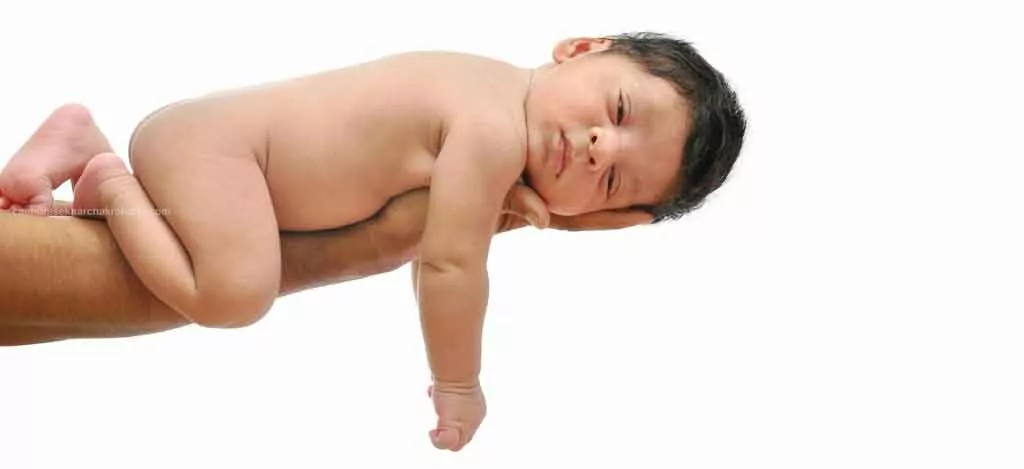 2 weeks newborn baby lies on his father's hand, portrait photography at home