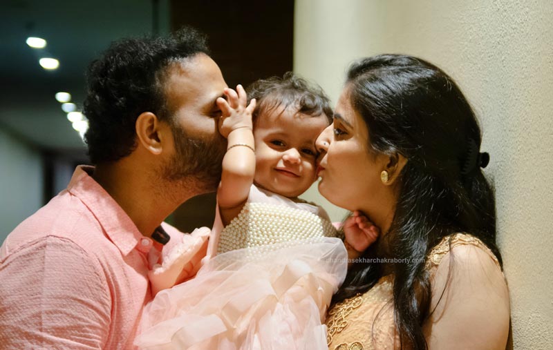 Mom & Dad Kissing the baby together for the first birthday