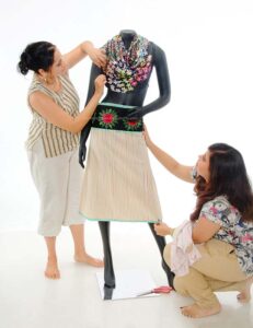 Fashion designers dressing her Maniquin during product photoshoot for advertising