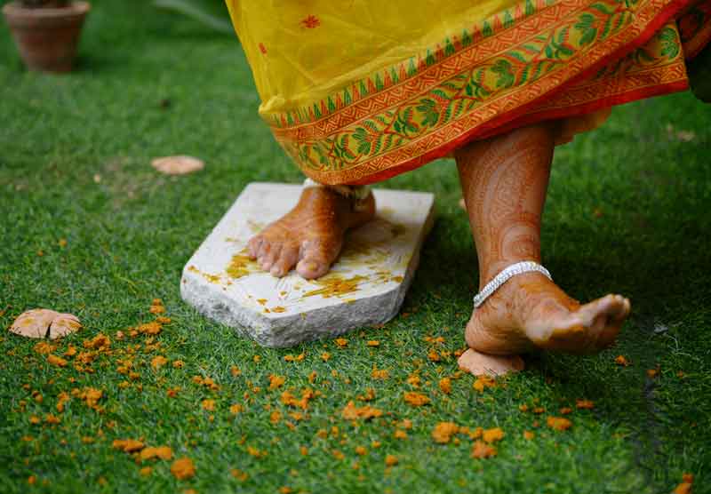 Bengali Bride is Breaking khari with the ankle after haldi ceremony